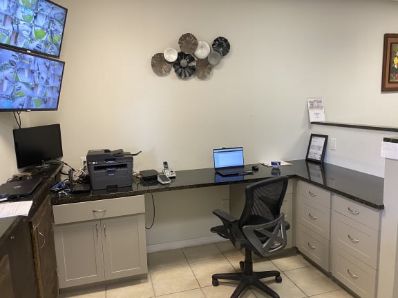 a desk with a computer and a printer on it