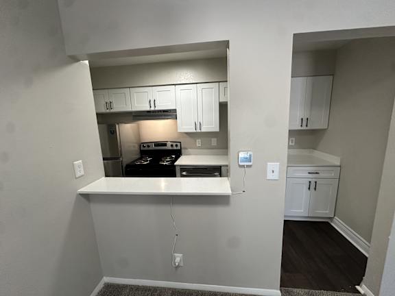 A kitchen with white cabinets and a black stove top oven.at Auburn Glen Apartments, Jacksonville
