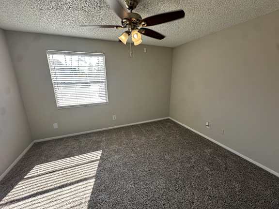 A room with a ceiling fan and a window letting in sunlight.at Auburn Glen Apartments, Jacksonville