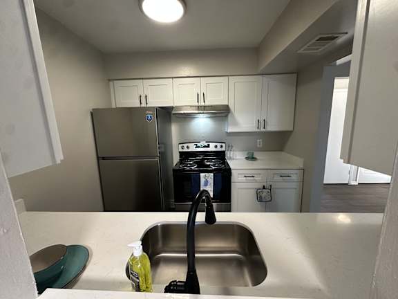 A kitchen with a sink, stove, and refrigerator.at Auburn Glen Apartments, Jacksonville