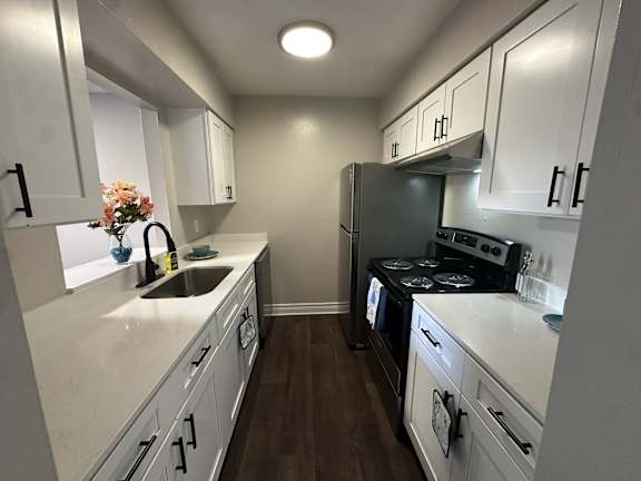 A kitchen with white cabinets and a black stove top oven.at Auburn Glen Apartments, Jacksonville