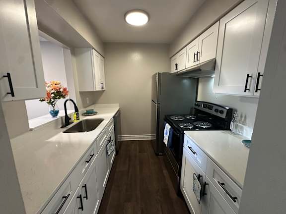A kitchen with white cabinets and a black stove top oven.at Auburn Glen Apartments, Jacksonville