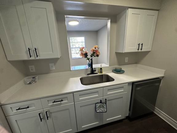 A kitchen with white cabinets and a sink.at Auburn Glen Apartments, Jacksonville