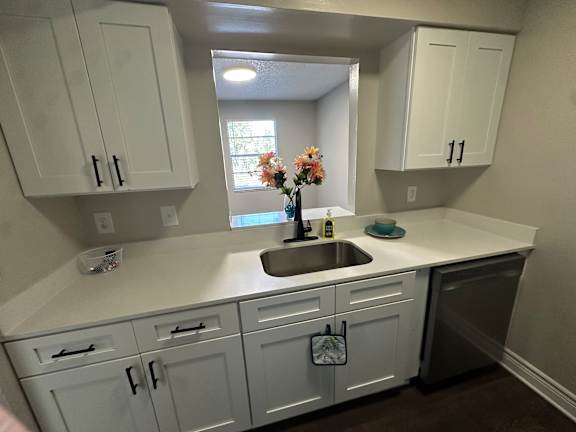 A kitchen with white cabinets and a sink.at Auburn Glen Apartments, Jacksonville