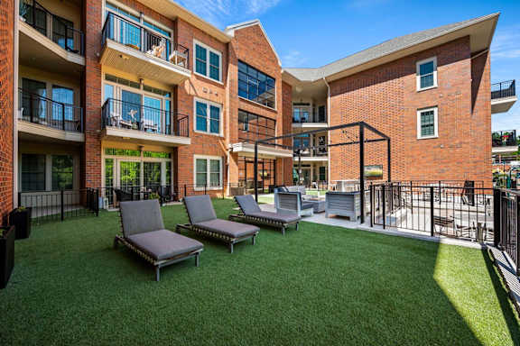 A sunny day at a modern apartment complex with a grassy courtyard.