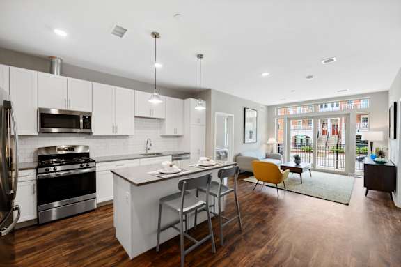 A modern kitchen with a large island and a view of the city.