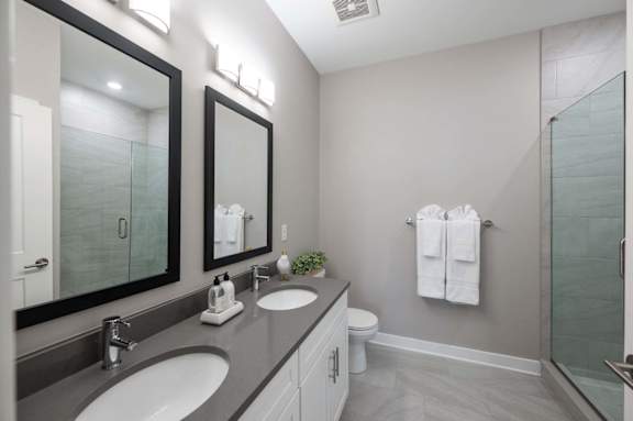 A bathroom with a white toilet, a sink, a mirror, and a towel rack.
