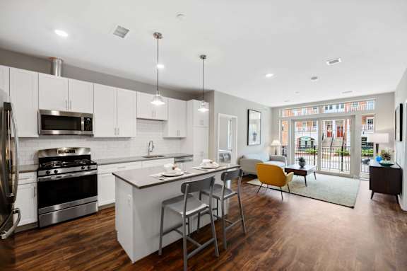 A modern kitchen with a large island and a view of the city.