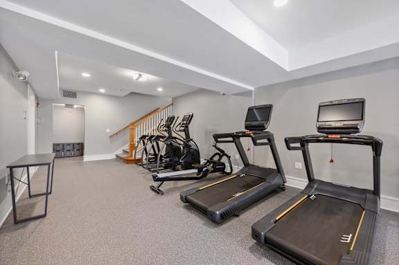 A spacious room with treadmills and elliptical machines.