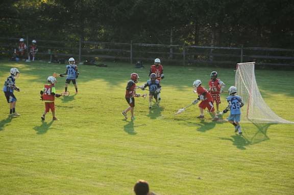 A group of people playing a game of lacrosse on a field.