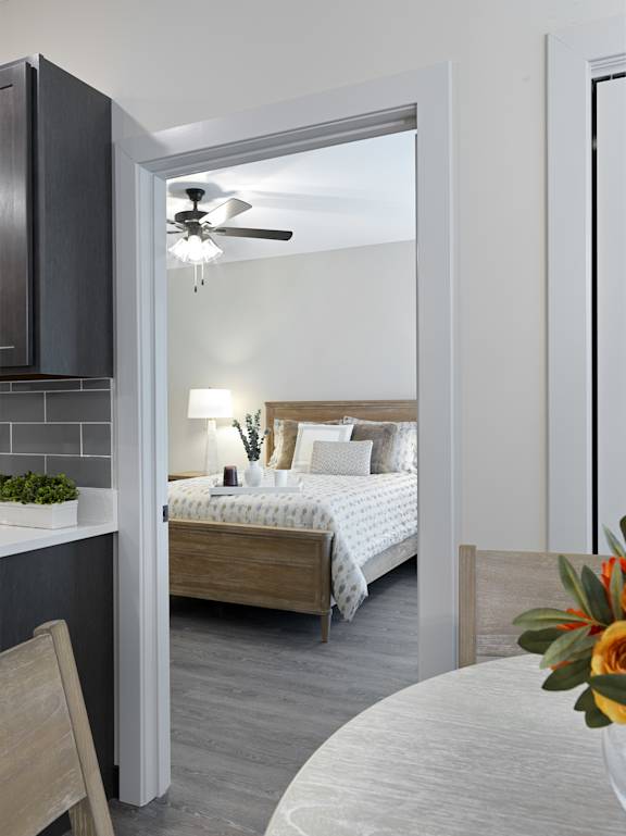 A bedroom with a bed, a chair, and a ceiling fan.