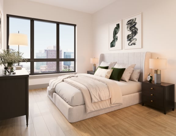 a bedroom with a large window and a bed with blankets and pillows at Bemiston Place Apartments, Clayton Missouri