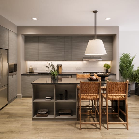 a kitchen with a large island with a table and chairs at Bemiston Place Apartments, Clayton