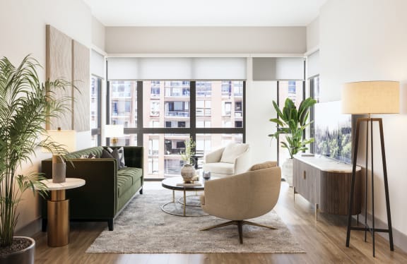 a living room with a green couch and a large window at Bemiston Place Apartments, Clayton, 63105