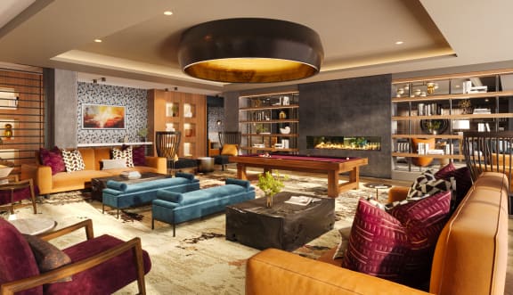 a living room filled with furniture and a pool table at Bemiston Place Apartments, Missouri, 63105