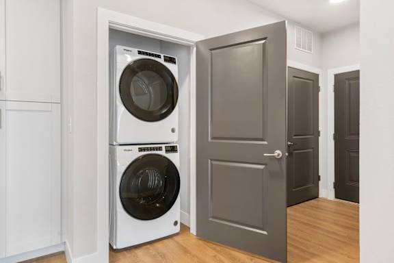 A laundry room with a washer and dryer stacked on top of each other.