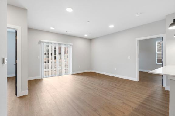 A white room with a wooden floor and a white gate.