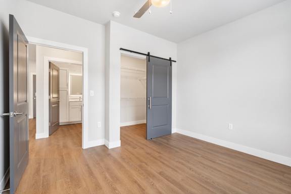A room with a grey door and a wooden floor.