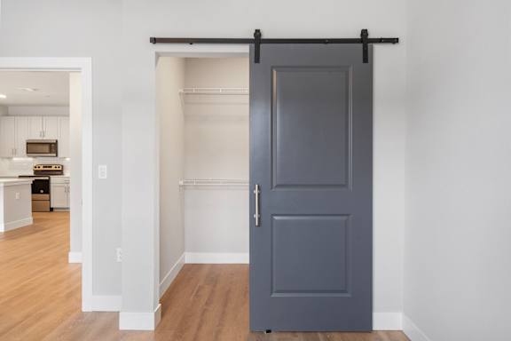 A grey door is open to a hallway.