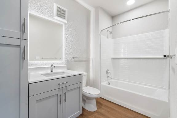 A white bathroom with a toilet, sink, and bathtub.