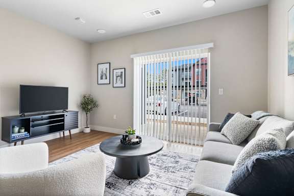 A living room with a flat screen TV and a white couch.