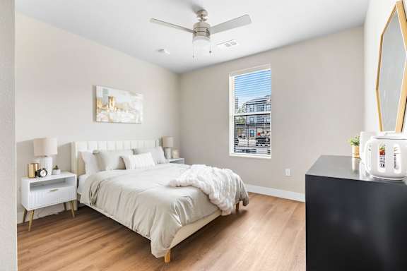 A bedroom with a large bed and a ceiling fan.