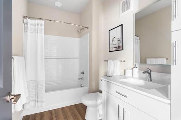 A white bathroom with a toilet, sink, and bathtub.