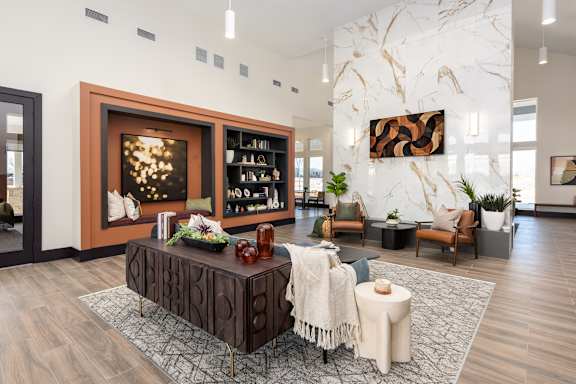 A modern living room with a wooden coffee table and a large painting on the wall at Hawk Ridge Apartments, Lake St. Louis, MO