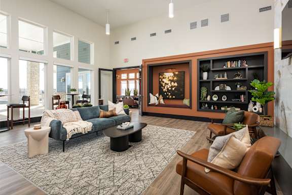A living room with a blue couch and a brown chair at Hawk Ridge Apartments, Lake St. Louis, MO 63367