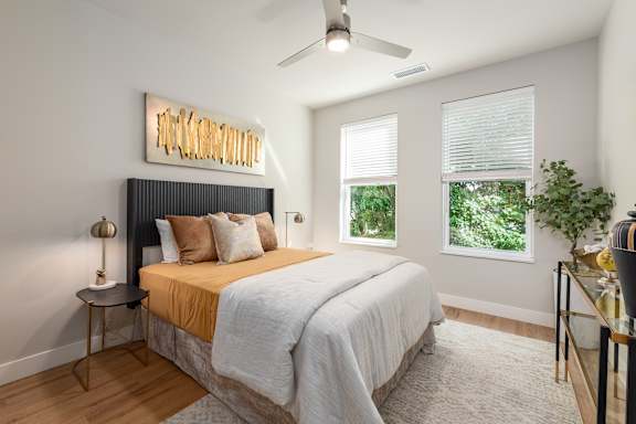 Bedroom with ceiling fan and two windows at Mila Apartments, Ellisville