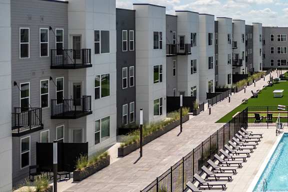 Pool deck with lounge chairs and courtyard walkway at Mila Apartments, Ellisville, Missouri