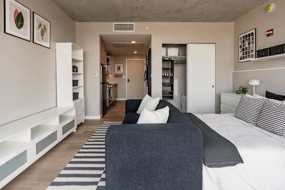 A living room with a grey couch and a striped rug. at One Foundry Way Apartments, Missouri, 63110
