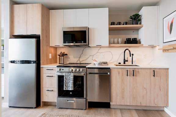 A modern kitchen with a stainless steel refrigerator and oven. at One Foundry Way Apartments, St Louis, MO