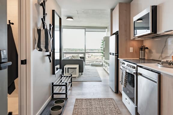 A modern kitchen with stainless steel appliances and a view of the city. at One Foundry Way Apartments, St Louis