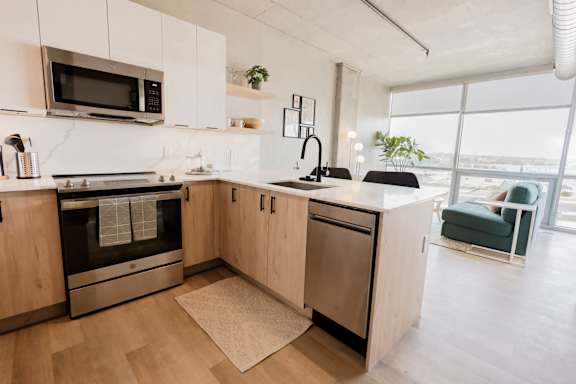 A modern kitchen with wooden cabinets and stainless steel appliances. at One Foundry Way Apartments, St Louis, Missouri