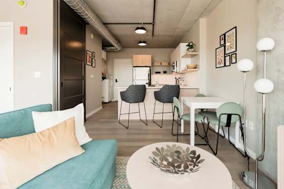A living room with a blue couch and a white coffee table. at One Foundry Way Apartments, St Louis, Missouri