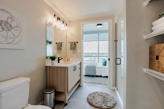 A bathroom with a toilet, sink, and a rug on the floor. at One Foundry Way Apartments, St Louis, MO