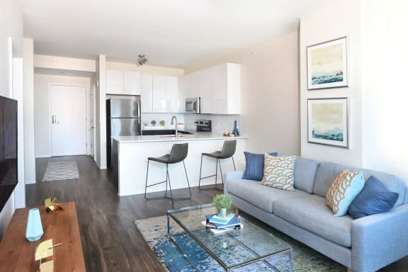 a living room with a couch and a kitchen at Two Twelve Clayton, Clayton, Missouri