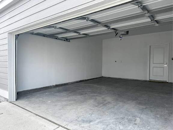 A garage with a white door and a concrete floor at French District Villas Apartments, Missouri