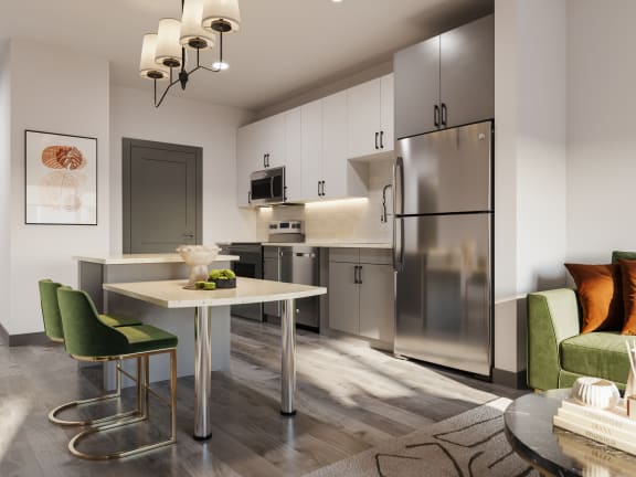 a kitchen and dining room with stainless steel appliances and a table and chairs at The Porter, Maryland Heights Missouri