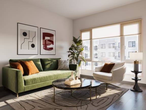 a living room with a green couch and a large window at The Porter, Maryland Heights, MO