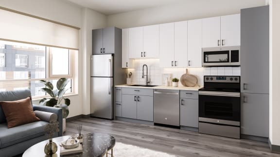a kitchen with stainless steel appliances and white cabinets at The Porter, Maryland Heights Missouri