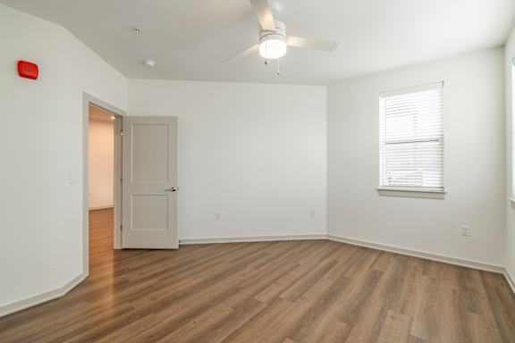 A room with a wooden floor and a ceiling fan.