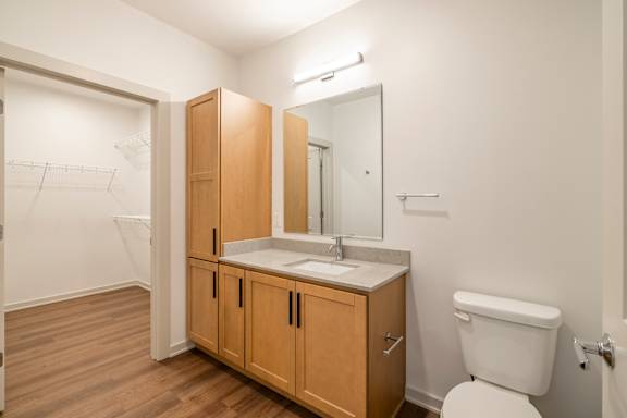 A bathroom with a toilet, sink, and medicine cabinet.
