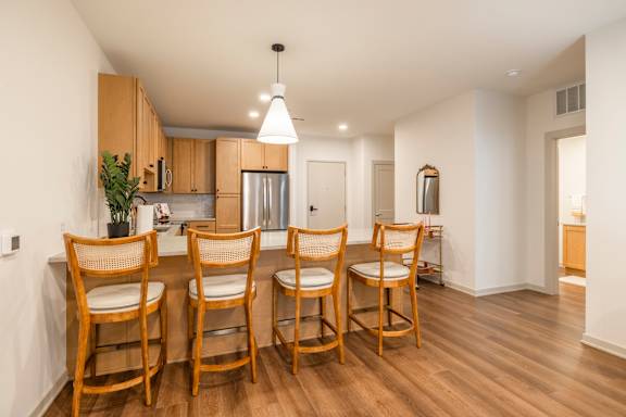 A kitchen with wooden chairs and a table.
