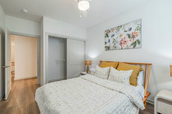 A bedroom with a large bed and a painting on the wall.