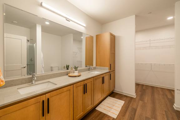A bathroom with two sinks and wooden cabinets.