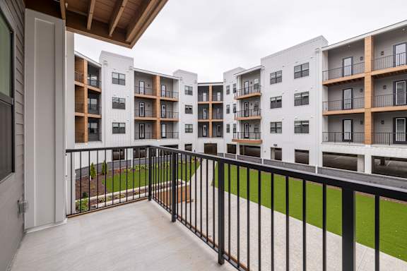 A balcony with black railings and a white door.