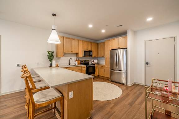 A kitchen with wooden cabinets and a white island.