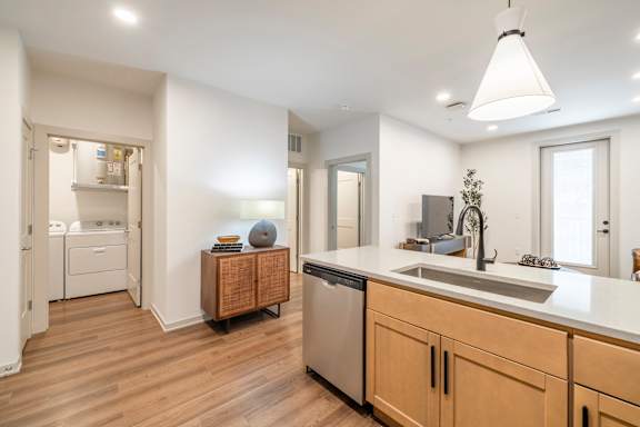A modern kitchen with wooden floors and a large island.